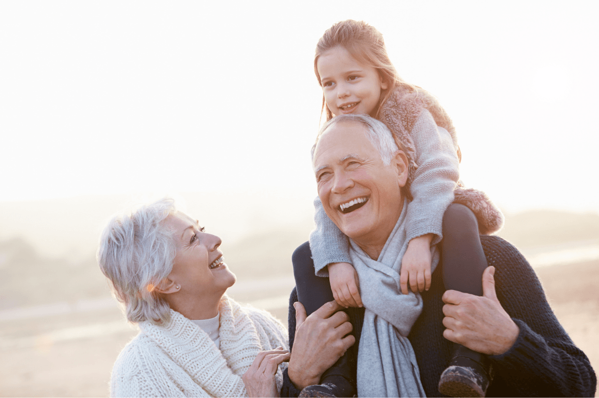 Abuelos sonriendo junto a su nieta en familia